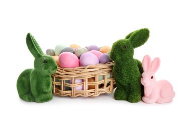 Easter bunnies and wicker basket with painted eggs isolated on white background