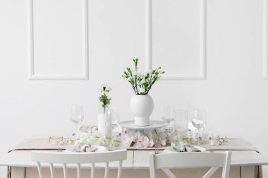 Beautiful table setting for International Women's Day celebration with eustoma and orchid flowers in light room