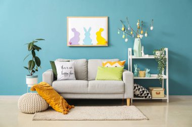 Interior of living room with Easter decor, sofa and shelving unit