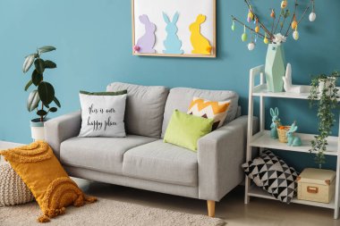 Interior of living room with Easter decor, sofa and shelving unit