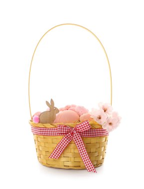 Basket with Easter eggs, flowers and bunny figure on white background