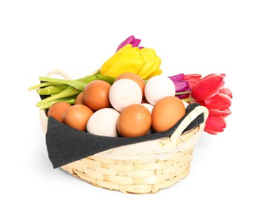 Basket with Easter eggs and tulip flowers isolated on white background