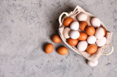 Wicker basket with Easter eggs on grey grunge background