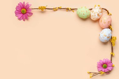 Composition with Easter eggs, plant branches and flowers on color background