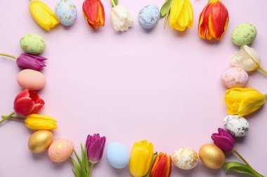 Frame made of painted Easter eggs and beautiful tulips on color background
