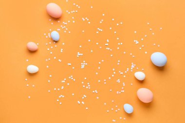 Composition with Easter eggs and confetti on color background