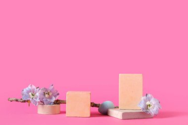 Composition with podiums, tree branch, flowers and and Easter egg on pink background