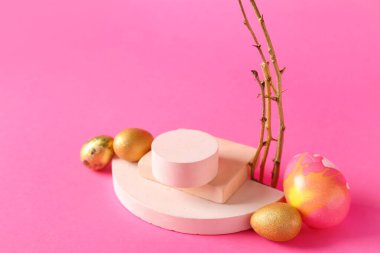 Composition with podiums, tree branches and Easter eggs on pink background