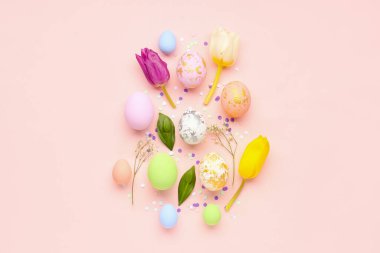 Beautiful composition with Easter eggs, flowers and confetti on pink background