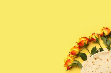 Creative composition with tortilla and beautiful rose flowers on yellow background