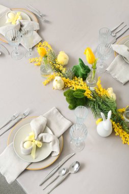 Festive table setting with painted eggs and flowers served for Easter celebration