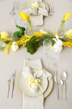 Festive table setting with painted eggs and flowers served for Easter celebration