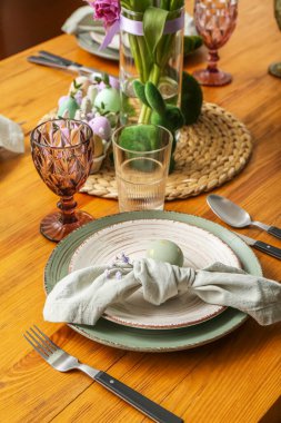 Table setting with painted egg, napkin and gypsophila flowers served for Easter celebration