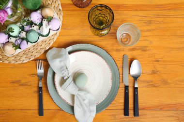 Festive table setting with painted eggs and flowers served for Easter celebration