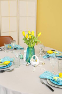 Beautiful table serving with painted eggs and tulip flowers served for Easter celebration