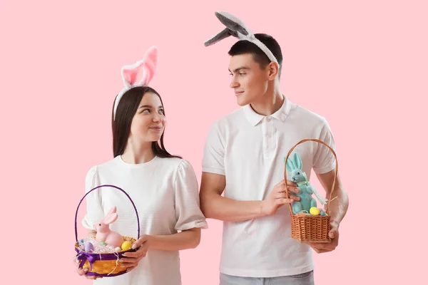 Happy Young Couple Bunny Ears Easter Eggs Rabbits Pink Background — Stock fotografie