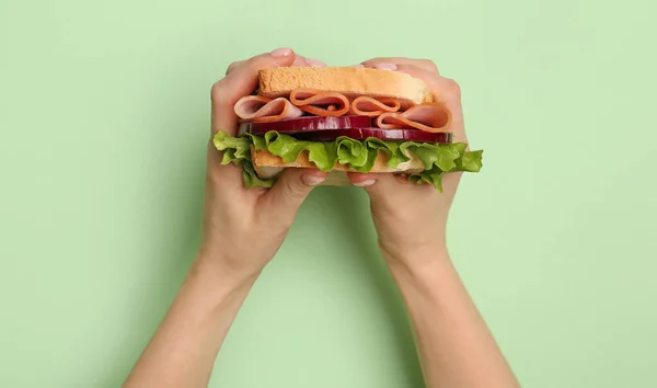 Manos Femeninas Sosteniendo Delicioso Sándwich Jamón Sobre Fondo Verde — Foto de Stock