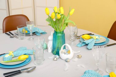 Beautiful table serving with painted eggs and tulip flowers served for Easter celebration
