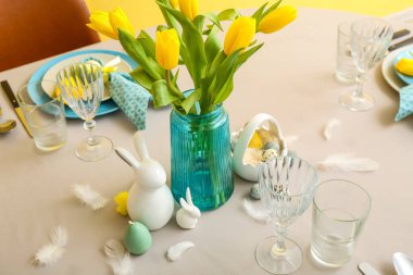 Beautiful table serving with painted eggs and tulip flowers served for Easter celebration