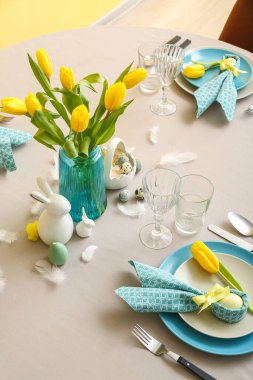 Beautiful table serving with painted eggs and tulip flowers served for Easter celebration