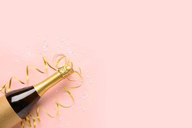 Composition with bottle of champagne, serpentine and sequins on pink background