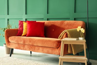 Red sofa with stylish cushions in living room