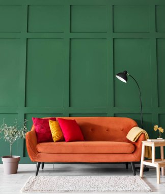 Interior of stylish living room with red sofa, stepladder and lamp