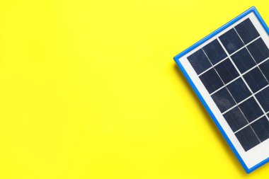 Portable solar panel on yellow background, closeup