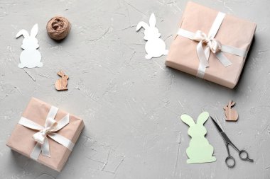 Frame made of Easter rabbits, gifts, scissors and rope on grunge background