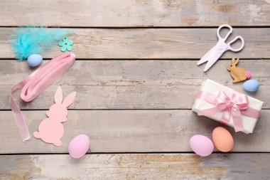 Frame made of gift, Easter decor, ribbon and scissors on wooden background