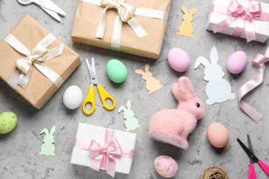 Gifts with Easter eggs and materials on grunge background