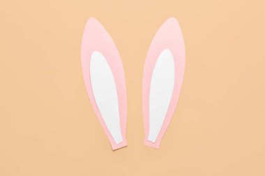 Paper bunny ears on beige background