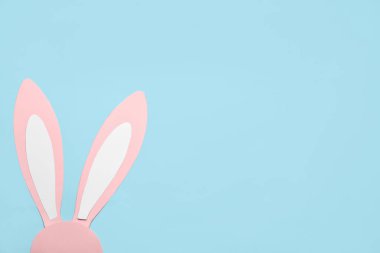Paper bunny ears on color background