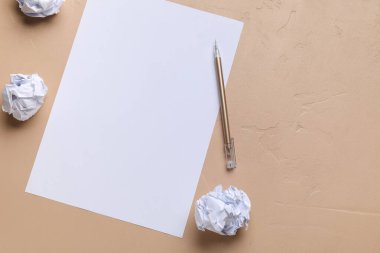 Blank sheet, crumpled paper balls and pen on color background. World Poetry Day celebration