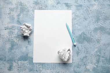 Blank sheet, crumpled paper balls and pen on grunge background. World Poetry Day celebration