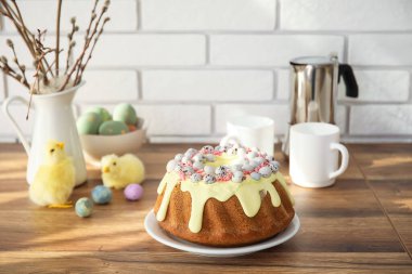 Easter cake with painted eggs and baby chickens on kitchen counter