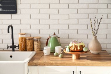 Dessert stand with Easter cake, painted eggs and bunny on kitchen counter