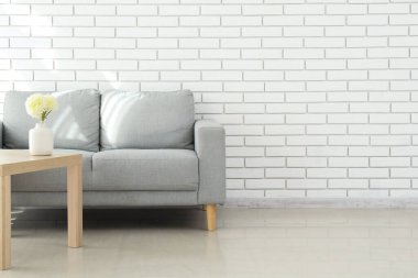 Stylish grey sofa in interior of living room