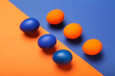 Painted Easter eggs on blue and orange background