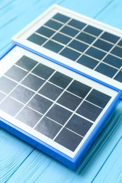 Portable solar panels on blue wooden background