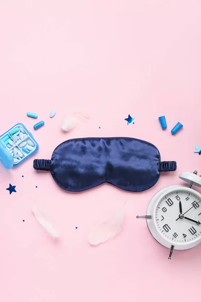 Composition with sleeping mask, alarm clock, pills and earplugs on pink background. World Sleep Day concept