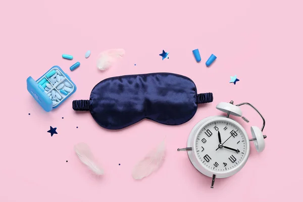 Composition with sleeping mask, alarm clock, pills and earplugs on pink background. World Sleep Day concept