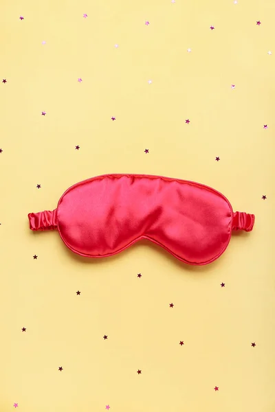 Composition with sleeping mask and confetti on yellow background. World Sleep Day concept