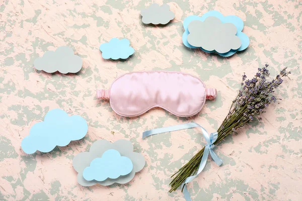Composition with sleeping mask, paper clouds and lavender flowers on grunge background. World Sleep Day concept