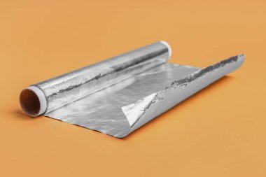 Roll of aluminium foil on color background