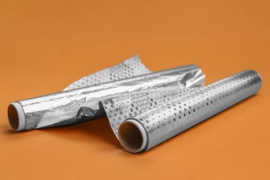 Rolls of aluminium foil on color background