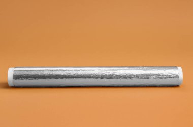 Roll of aluminium foil on color background