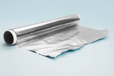 Roll of aluminium foil on color background