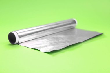 Roll of aluminium foil on green background