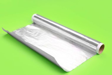 Roll of aluminium foil on green background
